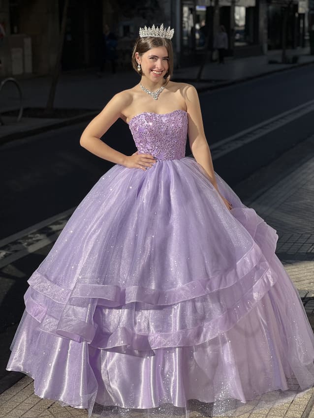 Vestido de quince lila estilo princesa con corset bordado y falda amplia de tul en capas, lucido en exterior con tiara y accesorios elegantes.